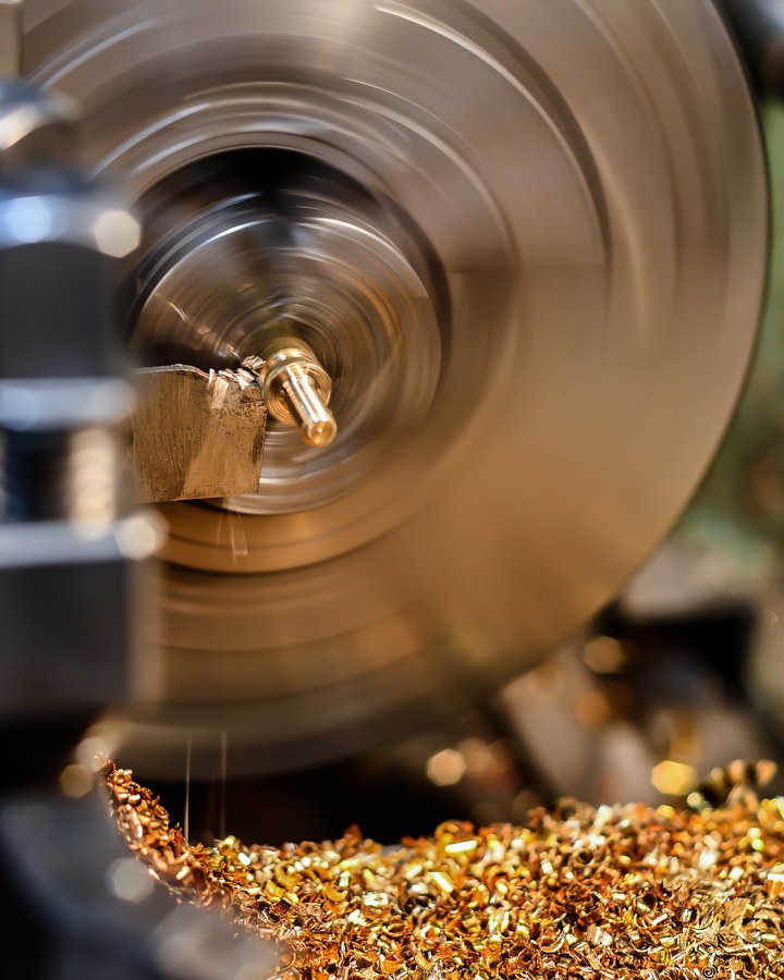 The chuck of a CNC lathe turning a steel component.