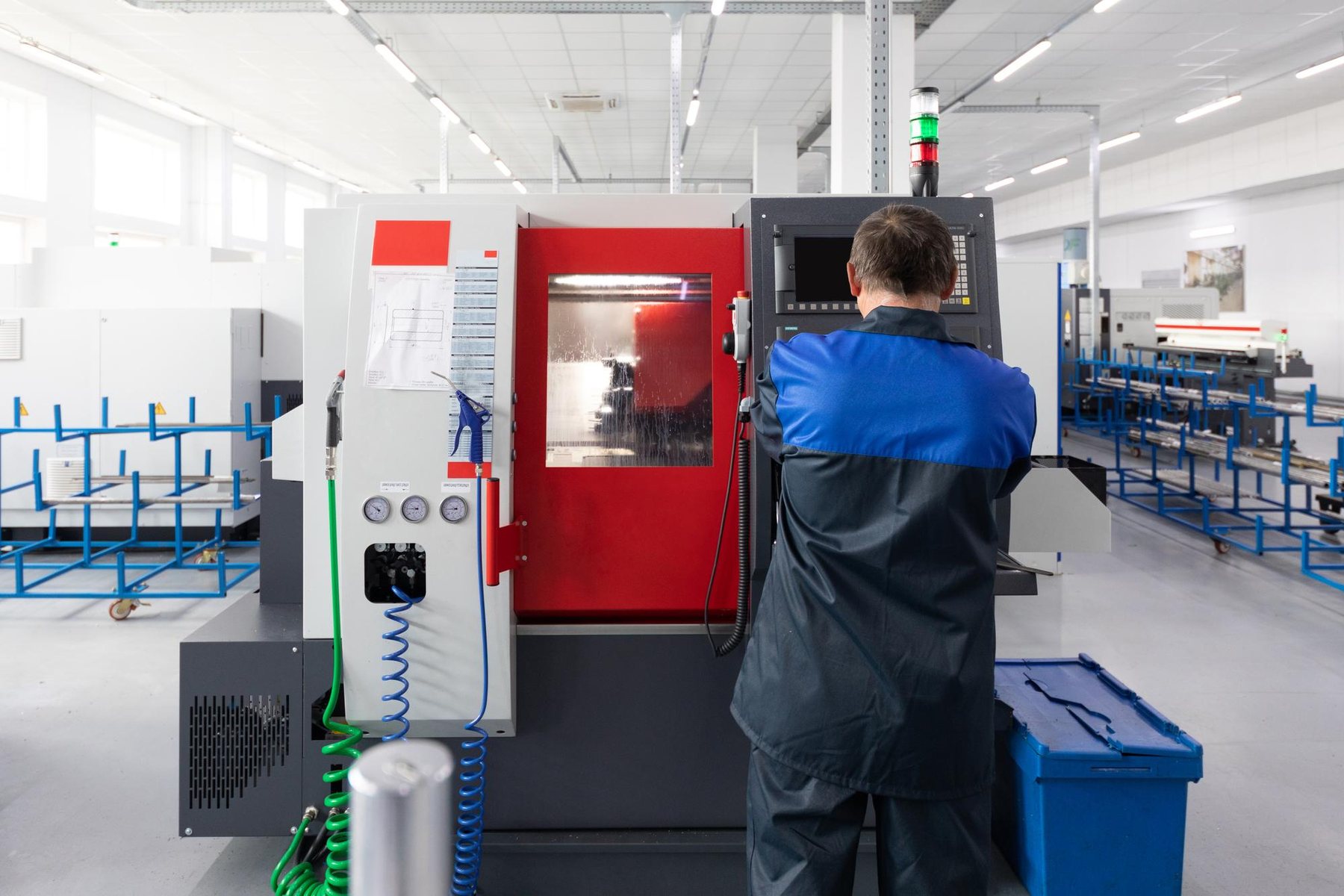 An operator at the control panel of a CNC machining centre.