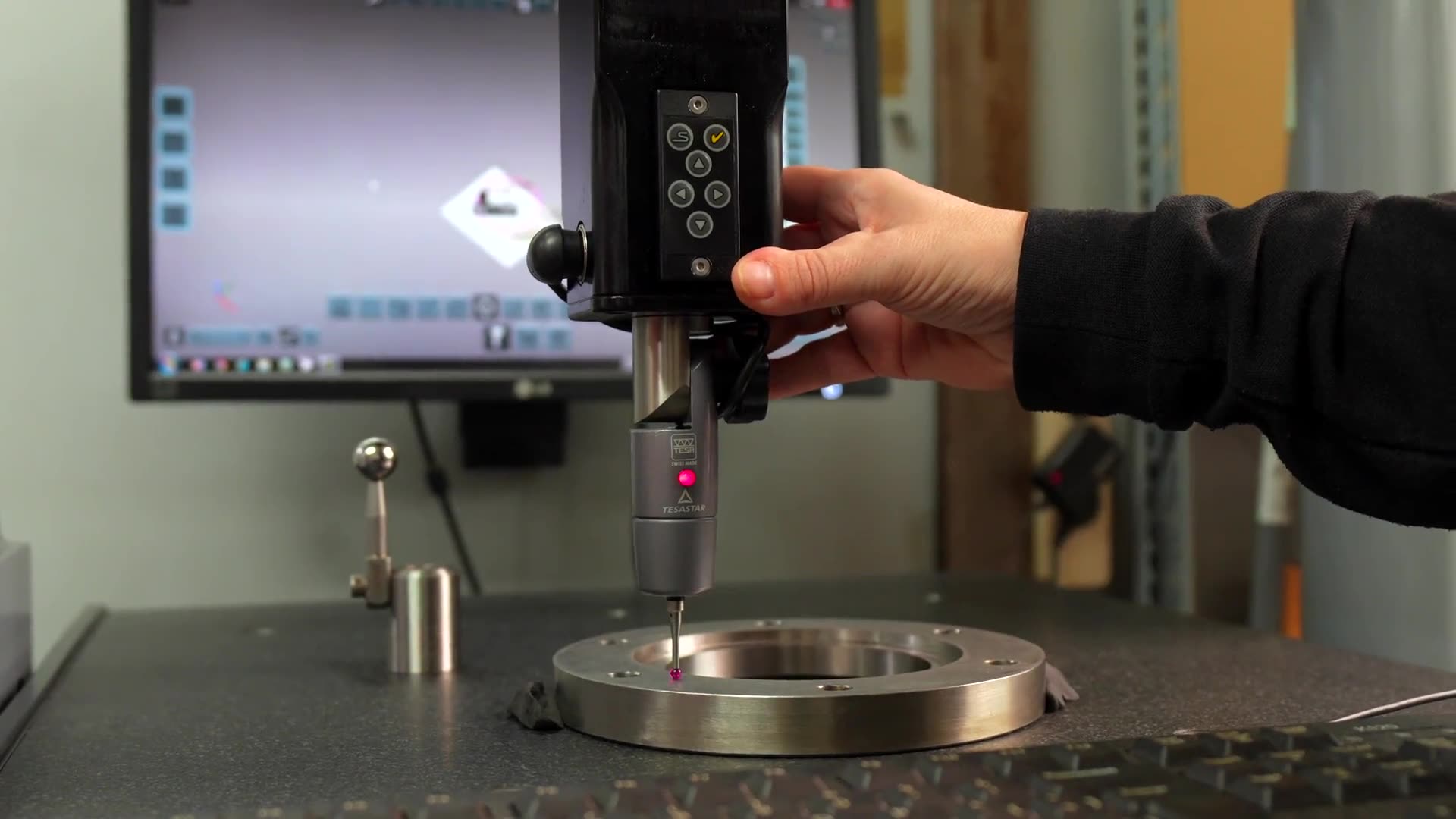 A coordinate measuring machine probing a machined component.