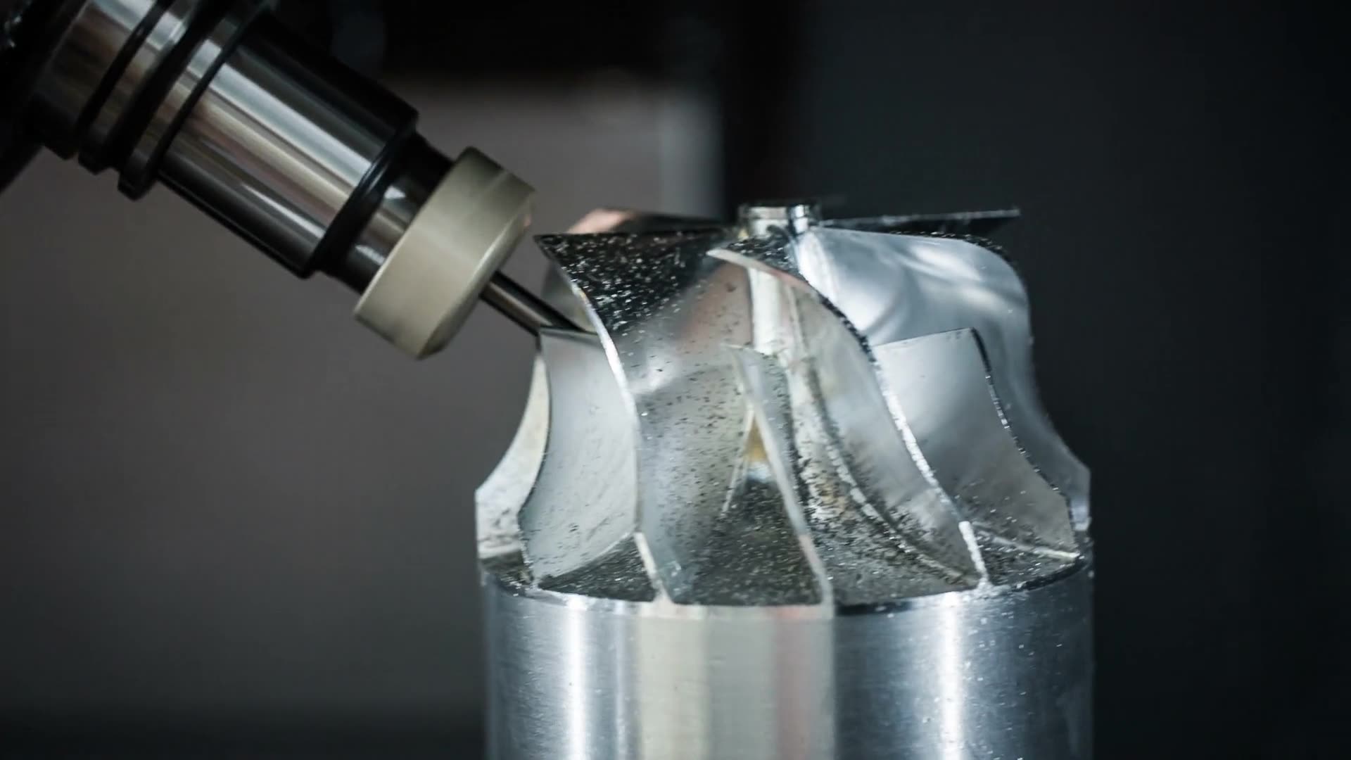A vertical machining centre cutting a steel component under coolant.